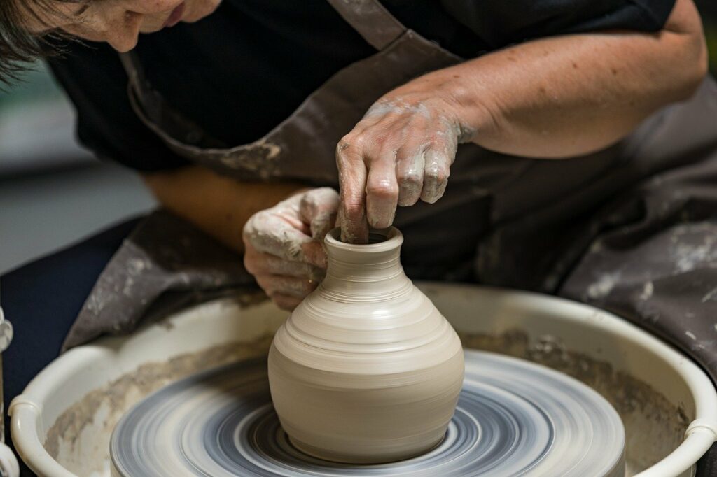 A potter working clay at a pottery wheel
