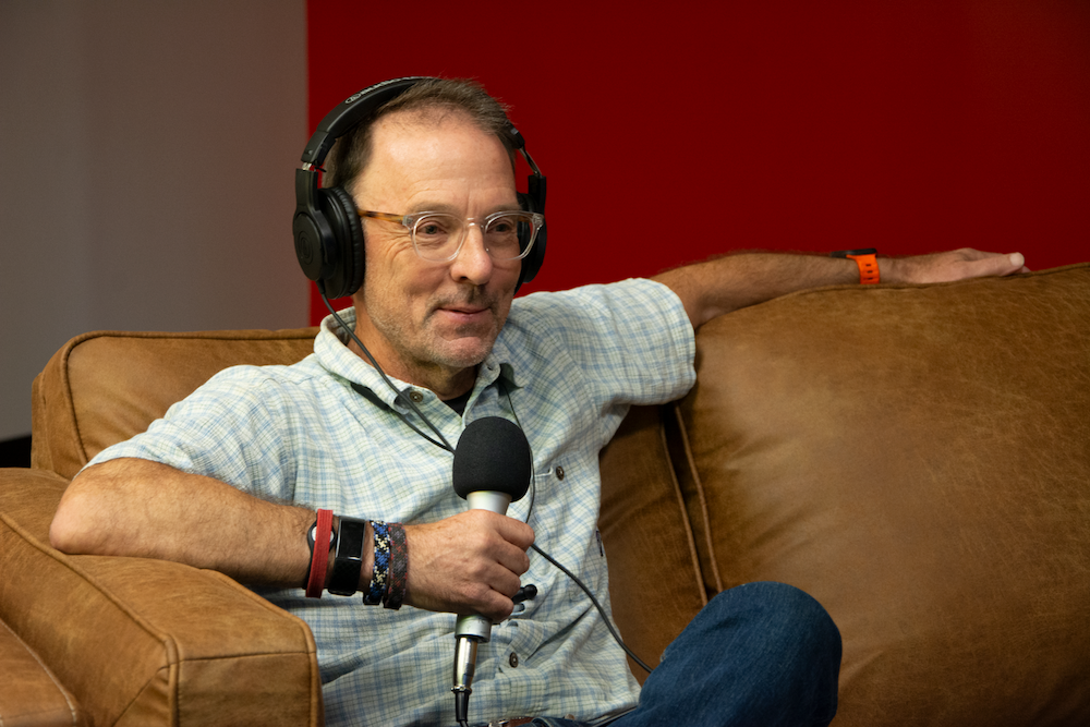 image of Eric Henry holding a mic during the podcast being recorded.