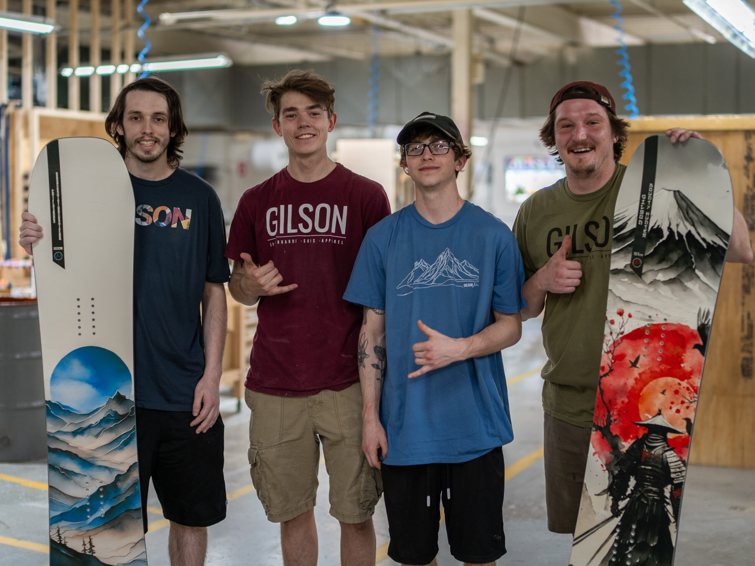 Four men wearing Gilson Snow shirts and holding snowboards
