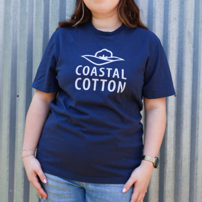 close up image of a young woman wearing a navy Coastal Cotton logo tee